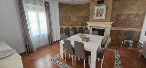 a dining room with a white table and chairs at Casa Rural Los Gaspares in La Carlota