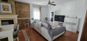 a living room with a couch and a tv at Casa Rural Los Gaspares in La Carlota