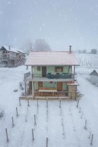 a house with a snow covered roof in a yard at Village House Belec in Belec