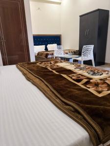 a bed with a brown blanket on top of it at Hotel Pilgriims in Varanasi