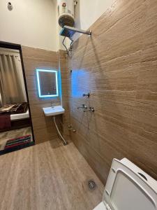 a bathroom with a shower with a sink and a toilet at Hotel Pilgriims in Varanasi