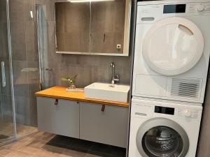 a bathroom with a washing machine and a sink at Åre Stay - VM huset centralt i Åre in Åre