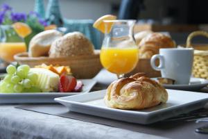 una mesa de desayuno con un plato de bollería y zumo de naranja en B&B The Beachhouse, en Oostduinkerke