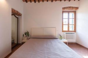 a large bed in a white room with a window at Appartamento Piazzetta 5 by ElbaSummer in Portoferraio