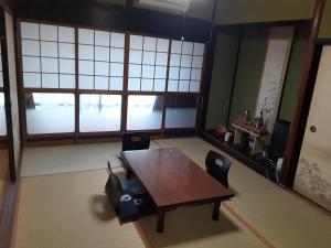 a table and chairs in a room with windows at 宿処 火打庵 火音 Kanon 