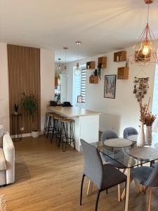 a kitchen and living room with a glass table and chairs at Chez Audrey in Dinan