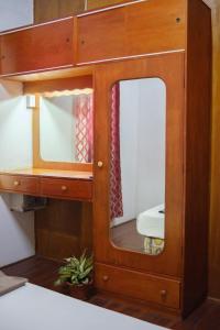 a wooden cabinet with a mirror in a room at sunny's homestay in Singatoka