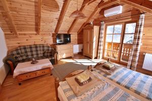 a bedroom in a log cabin with a bed and a tv at Hanga Vendégház Parád in Parád
