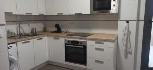 a kitchen with white cabinets and a stove top oven at Casa Carmen in Serón
