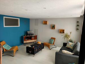 un salon avec un canapé, des chaises et une télévision dans l'établissement Logement de Charme en centre ville, à Lesneven