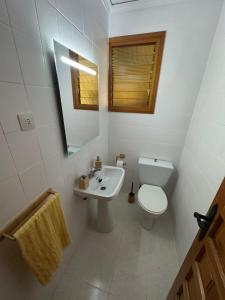 a bathroom with a toilet and a sink and a mirror at Casa Rural El Olivo in Alatoz +12 photos