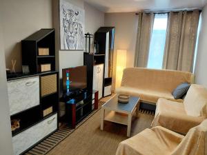 a living room with a couch and a table at Sunny days -cozy apartment in Boutersem