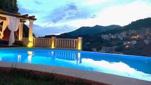a blue swimming pool with a gazebo and a city at Hostal El Cerro - Only Adults in Pedro Bernardo