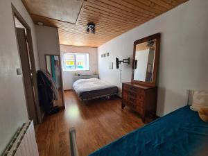 a bedroom with a bed and a dresser and a mirror at Maison sur Ile de Noirmoutier in LʼÉpine
