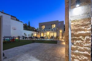 a house with a stone wall and a yard at Villa Fotinou Heated Pool & Free Bikes awaits in Fotinós