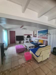 a living room with a couch and a table at Maison sur Ile de Noirmoutier in LʼÉpine