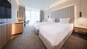 a hotel room with two beds and a television at Hotel Complex SamElyon in Samokov