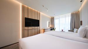 a hotel room with two beds and a flat screen tv at Hotel Complex SamElyon in Samokov