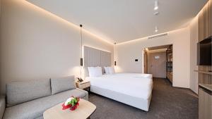 a hotel room with a bed and a couch at Hotel Complex SamElyon in Samokov