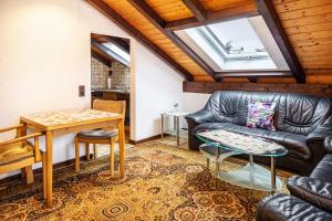a living room with a leather couch and a table at Ferienwohnung Hufenus in Breisach am Rhein