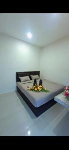 a bedroom with a bed with flowers on it at Chamim Apartments Koh Lanta ชามิม in Phra Ae beach