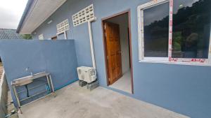 a blue house with a door and a window at Chamim Apartments Koh Lanta ชามิม in Phra Ae beach