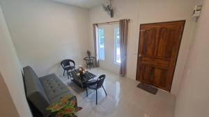 a living room with a couch and a table and chairs at Chamim Apartments Koh Lanta ชามิม in Phra Ae beach