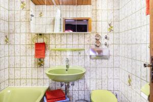 a tiled bathroom with a sink and a toilet at Ferienwohnung Hufenus in Breisach am Rhein +18 photos