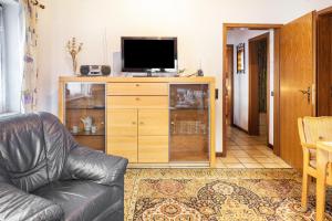 a living room with a couch and a television on a cabinet at Ferienwohnung Hufenus in Breisach am Rhein