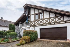 a white house with a brown garage door at Ferienwohnung Hufenus in Breisach am Rhein