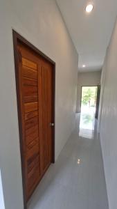 a hallway with a wooden door in a house at Chamim Apartments Koh Lanta ชามิม in Phra Ae beach