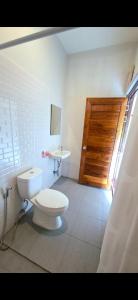 a bathroom with a toilet and a sink and a wooden door at Chamim Apartments Koh Lanta ชามิม in Phra Ae beach