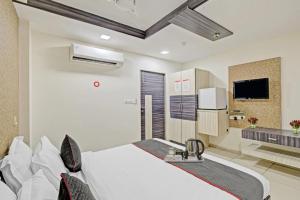 a bedroom with a white bed and a tv at Hotel Marina FREE Airport Drop in New Delhi