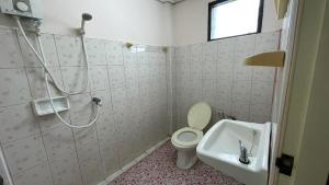 Un baño con ducha, inodoro y lavabo. en Thaen Thong Hotel, en Lamphun