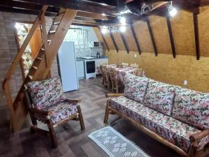 a dining room with couches and a table and a kitchen at Recanto Mauá - Chalé Amarílis in Resende