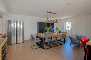 a kitchen and dining room with a table and a refrigerator at New! Guesthouse Eindeloos in 't Zand