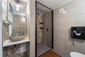 a bathroom with a sink and a shower with a mirror at Bohém Kabin & Wellness in Kismaros
