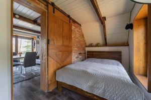 a bedroom with a bed and a brick wall at Bohém Kabin & Wellness in Kismaros