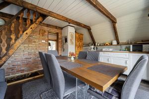 a kitchen and dining room with a wooden table and chairs at Bohém Kabin & Wellness in Kismaros +27 photos