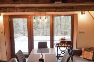 a living room with a table and a large window at Bohém Kabin & Wellness in Kismaros