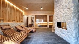 a living room with two benches and a fireplace at Chata Kúria Tále, Chopok JUH in Brezno