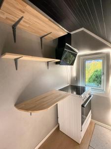 eine kleine Küche mit einer Theke und einem Fenster in der Unterkunft CC`s Green house in Tromsø + 35 Fotos