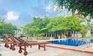 a pool with two lounge chairs next to a house at Aqua Hotel Yala in Yala