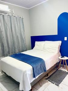 a blue and white bedroom with a large bed at Recanto Monte Trigo in São Francisco do Sul