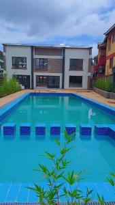 una gran piscina con sillas frente a un edificio en Cynergy 1b Apartment, Muthiga , Waiyaki Way, en Nairobi
