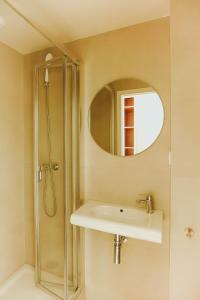 a bathroom with a sink and a shower with a mirror at Micampus Braga Student Residence in Braga