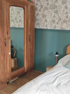 a bedroom with a wooden cabinet and a bed at Grande chambre cosy très proche centre ville in Le Mans