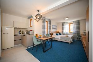 een keuken en een woonkamer met een tafel en een bed bij Casa Laurea in Dubrovnik