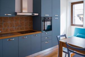 a kitchen with blue cabinets and a table at GUBBIO LIVING - by Angeloni in Gubbio