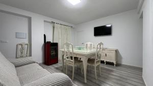 a living room with a table and chairs and a tv at CASA DEL VIDRIO in Castril